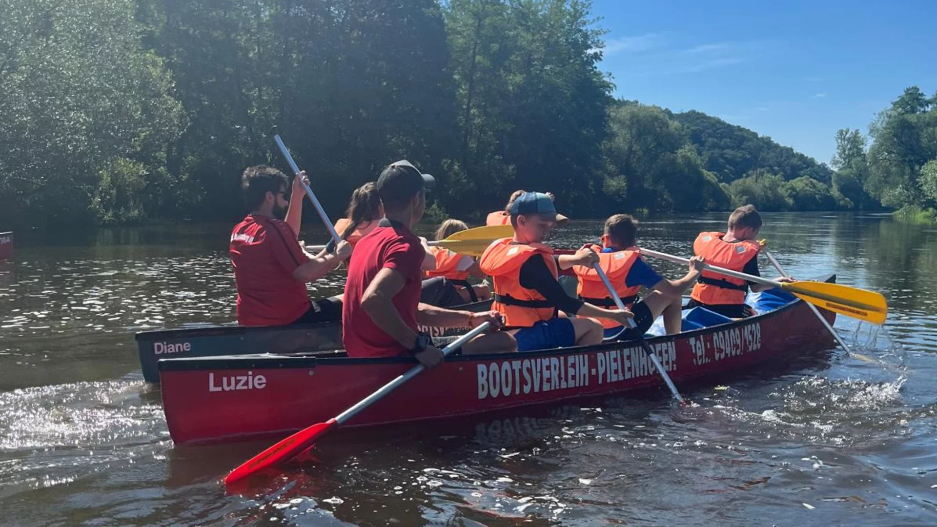 Kinder und Jugendliche bei der Bootsfahrt auf dem Regen
